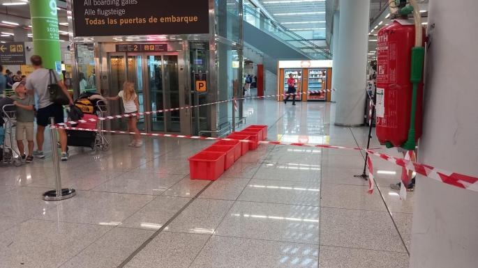 Buckets line the terminal floor as maintenance crews cordon off flooded areas to manage leaks caused by the storm.