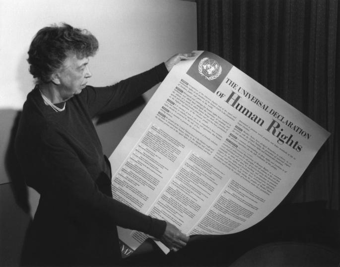 Eleanor Roosevelt, chair of the drafting committee, holding the paper.