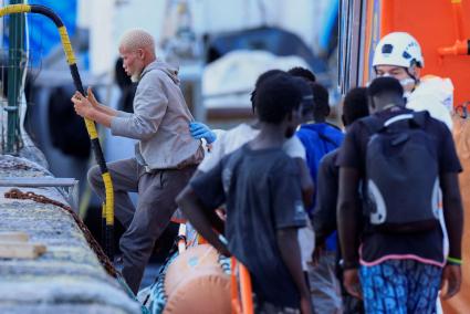 A migrant disembarks from a Spanish coast guard vessel, in the port of Arguineguin